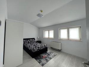 a white bedroom with a bed and a tv at Hotel Lavanda in Piteasca