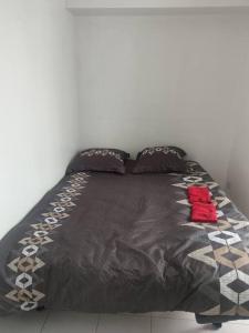 a bed with a black comforter and two pillows at Expérience urbaine in Aubervilliers