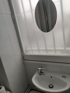 Baño pequeño con lavabo y espejo en Expérience urbaine en Aubervilliers