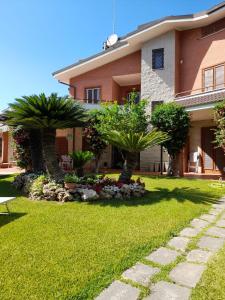 dom z dwoma palmami na dziedzińcu w obiekcie Il Sogno delle Rondini w mieście Palidoro