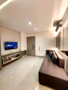 sala de estar con sofá y TV de pantalla plana en Estúdio Moderno e Elegante no Vertigo, en Campo Grande