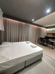 1 dormitorio con 1 cama blanca grande y piano en Estúdio Moderno e Elegante no Vertigo, en Campo Grande