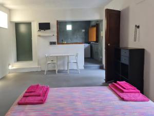 Habitación con cocina y mesa con toallas rosas. en Nutt House with garden near the sea, en Altavilla Milicia