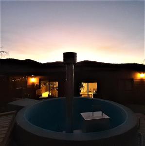 a swimming pool in front of a house with the sunset at Casa con linda vista de montaña y tinaja in Curacaví