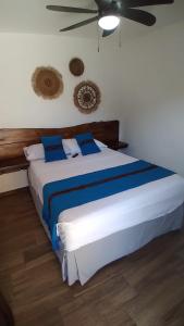 - une chambre avec un grand lit blanc et des oreillers bleus dans l'établissement Hotel María Isabel Ataco, à Concepción de Ataco