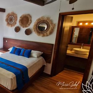 a bedroom with a bed and a sink and a mirror at Hotel María Isabel Ataco in Concepción de Ataco