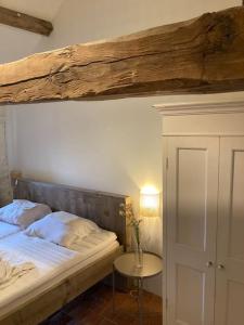 1 dormitorio con 1 cama con vigas de madera encima en Ruime woning in de Morvan, Bourgogne met seizoensgebonden zwembad, en Brassy