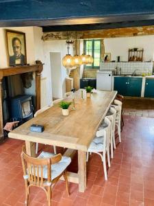 una gran mesa de madera en una cocina con sillas en Ruime woning in de Morvan, Bourgogne met seizoensgebonden zwembad, en Brassy