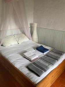 Una cama con sábanas blancas y toallas. en Ruime woning in de Morvan, Bourgogne met seizoensgebonden zwembad, en Brassy