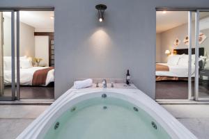a bath tub in a room with two beds at Suites Giorgio in Mexico City