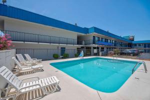 uma piscina com espreguiçadeiras ao lado de um edifício em Motel 6-Russellville, AR em Russellville