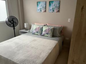 a small bedroom with a bed and a fan at Apto familiar con vista a la ciudad in Envigado