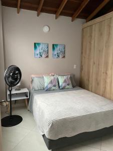 a bedroom with a large bed and a fan at Apto familiar con vista a la ciudad in Envigado