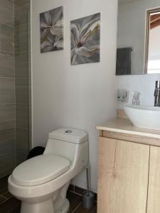 a bathroom with a white toilet and a sink at Apto familiar con vista a la ciudad in Envigado