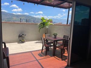 a table and chairs on a balcony with a view at Apto familiar con vista a la ciudad in Envigado