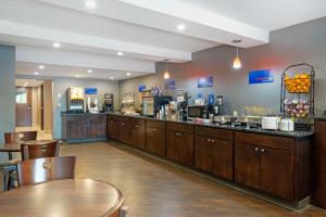 a restaurant with a bar with wooden cabinets and tables at Best Western University Inn at Valparaiso in Valparaiso