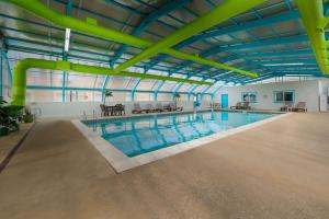 a large indoor swimming pool with yellow pipes at Best Western Detroit Livonia in Livonia