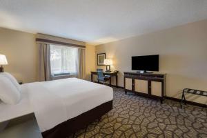 a hotel room with a bed and a flat screen tv at Best Western Detroit Livonia in Livonia