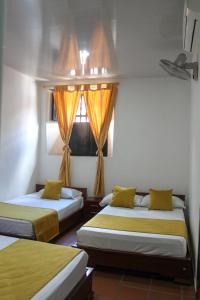 a bedroom with two beds and a window at Hotel Colonial San Felipe in Girón