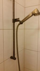 a shower head with a hose in a bathroom at Gästezimmer in Zurich