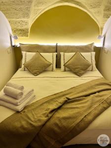 法萨诺Calamedde Guest House nel Centro Storico Pugliese的一张带枕头的大床