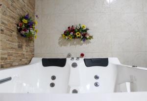 a bathroom with a bath tub with flowers on the wall at Hotel Colonial San Felipe in Girón