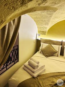 um quarto com uma cama com toalhas em Calamedde Guest House nel Centro Storico Pugliese em Fasano