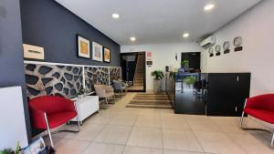 a lobby with a waiting room with red chairs at LAVIDA in Abidjan