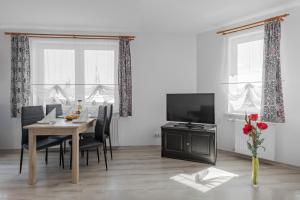 a dining room with a table and a television at Pensjonat KoGa in Kołobrzeg