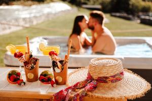 a couple kissing in front of a hot tub at Holiday House Sunset Spa in Šentjernej