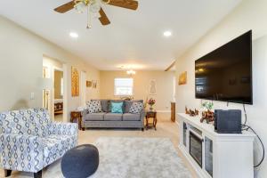 a living room with a couch and a flat screen tv at Cozy Oklahoma Retreat with Covered Patio and Gas Grill in Mustang