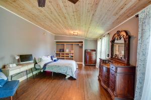 ein Schlafzimmer mit einem Bett und einer Holzdecke in der Unterkunft Lakefront West Sand Lake Home with Beach Access! 