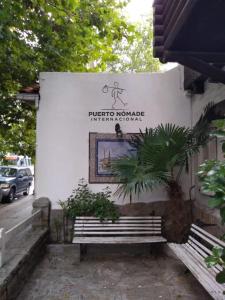 un cartel con un banco frente a un edificio en Puerto Nómade Hostel Internacional en Mar del Plata