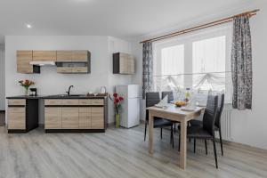 a kitchen and dining room with a table and chairs at Pensjonat KoGa in Kołobrzeg