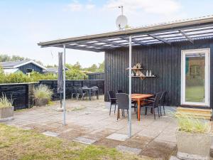 pérgola en un patio con mesa y sillas en 6 person holiday home in S by en Sæby