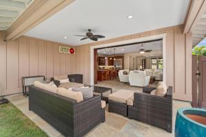 a patio with wicker furniture and a living room at Big Island Holua Kai 7072 home in Kailua-Kona