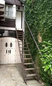 a metal staircase next to a building with a door at Puerto Nómade Hostel Internacional in Mar del Plata