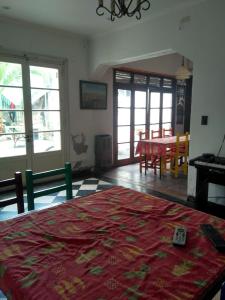 Sala de estar con cama roja y mesa en Puerto Nómade Hostel Internacional en Mar del Plata