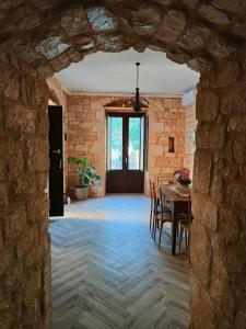 una sala da pranzo con tavolo e parete in pietra di Petra Barocca a Scicli