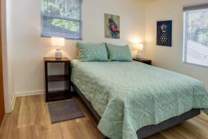 Crescent City的住宿－Crescent Lake Sanctuary - Renovated with Views!，一间卧室配有一张带绿色被子的床和两盏灯。