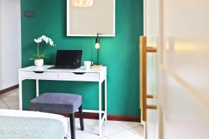 里米尼的住宿－APPARTAMENTI LEONE - Vista Mare Rimini，一张白色的桌子,上面有一台笔记本电脑,放在绿色的墙上