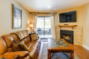 a living room with a leather couch and a fireplace at Chic and Cozy Breck Condo Ski-InandSki-Out at Peak 8! in Breckenridge