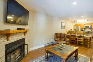 a living room with a fireplace and a table at Chic and Cozy Breck Condo Ski-InandSki-Out at Peak 8! in Breckenridge