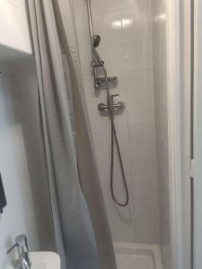 La salle de bains est pourvue d'une douche avec rideau de douche. dans l'établissement Séjour chaleureux, à Aubervilliers