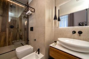 a bathroom with a sink and a toilet and a shower at MAMALU - Studios and Suites in Naples