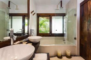 ein Bad mit einer Badewanne, einem Waschbecken und einer Dusche in der Unterkunft Beachfront suites in Tulum beach in Tulum