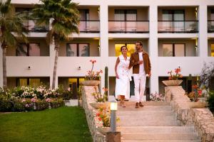 una novia y un novio caminando por las escaleras de un hotel en Paradisus Los Cabos - Adults Only - All Inclusive, en Cabo San Lucas
