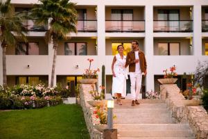 une mariée et un marié marchant dans les escaliers d'un hôtel dans l'établissement Paradisus Los Cabos - Adults Only - All Inclusive, à Cabo San Lucas