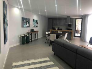 Una sala de estar con un sofá y una cocina. en Villa Sol e Mar, en Ribeira Brava