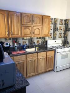 a kitchen with wooden cabinets and a sink and a stove at CHEZ NDAYE AMY in Dakar